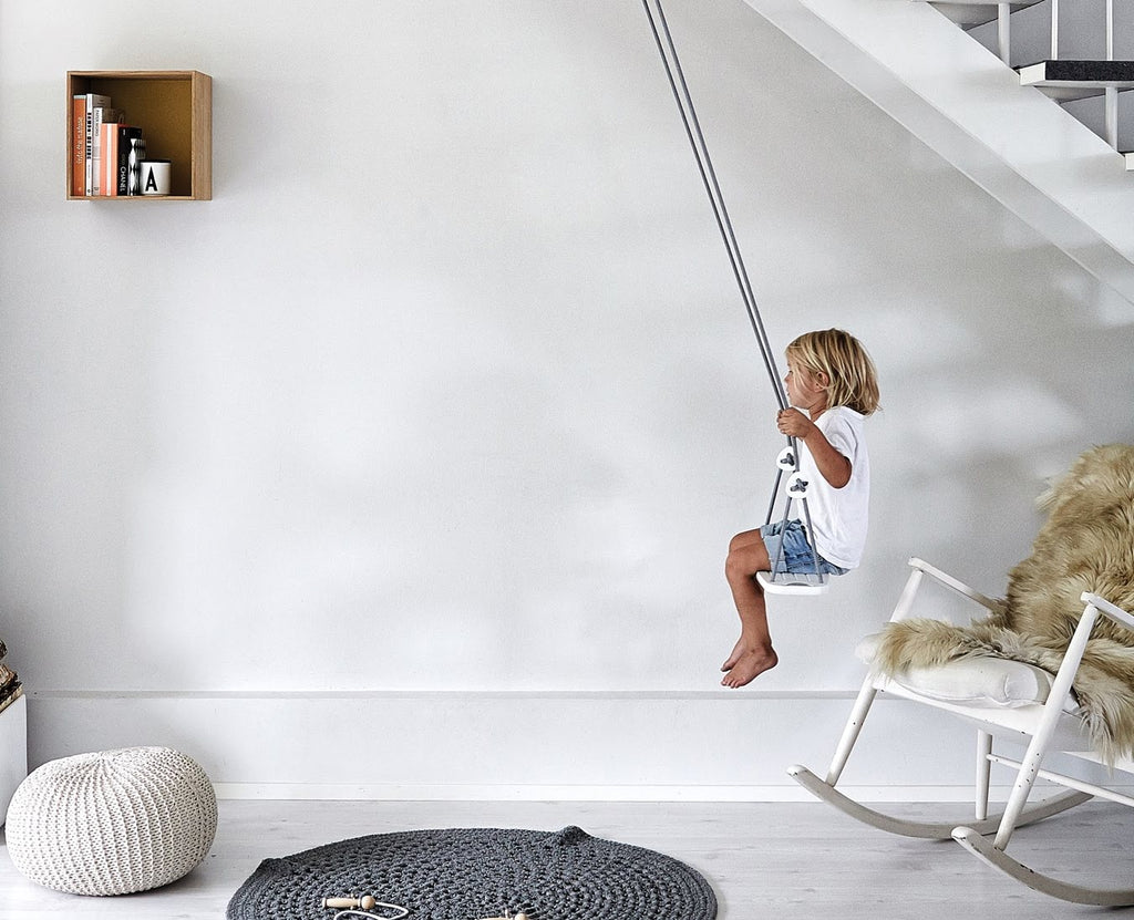 Kind auf Indoor Kinderschaukel in weiß zu Hause