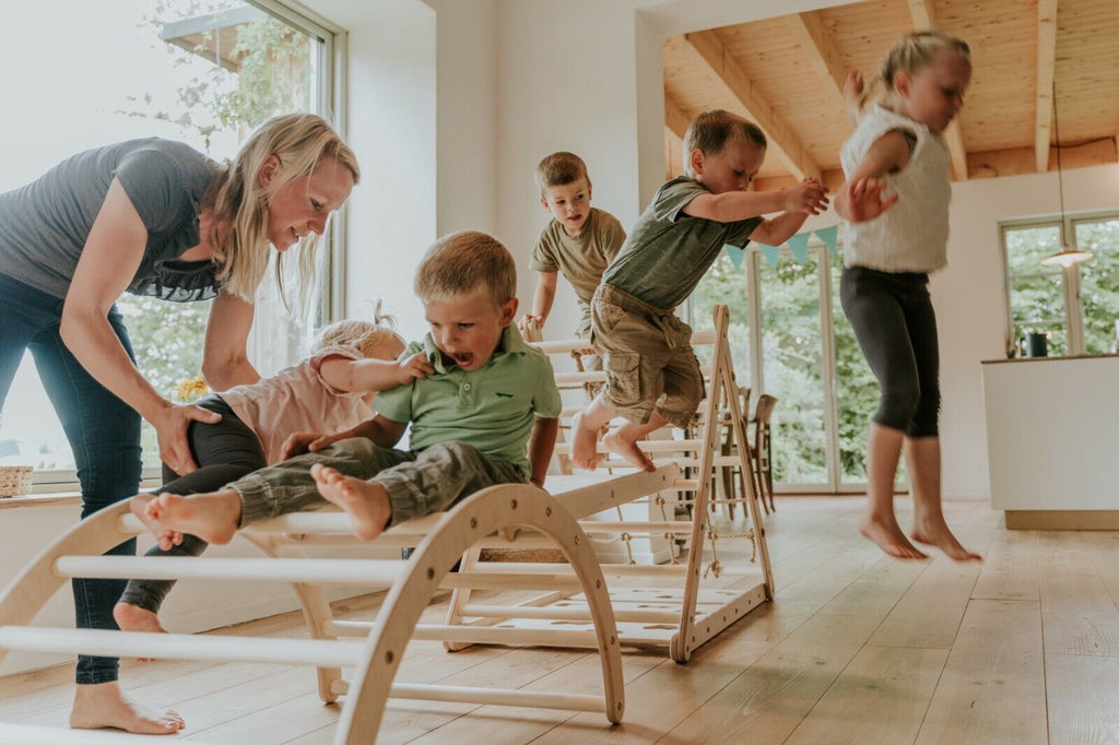 fünf Kinder auf Klettergerüst aus Holz Indoor mit Mutter