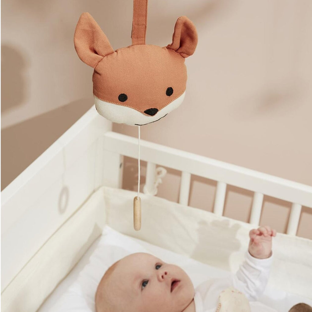 Spieluhr Edvin Fuchs mit Schnur hängt über Baby im Bett