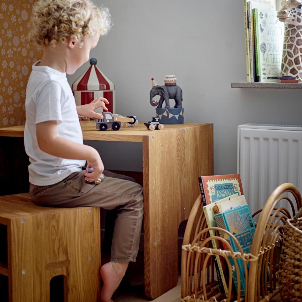 Kind sitzt auf Kinderhocker aus Eiche am Kindertisch aus eiche und spielt