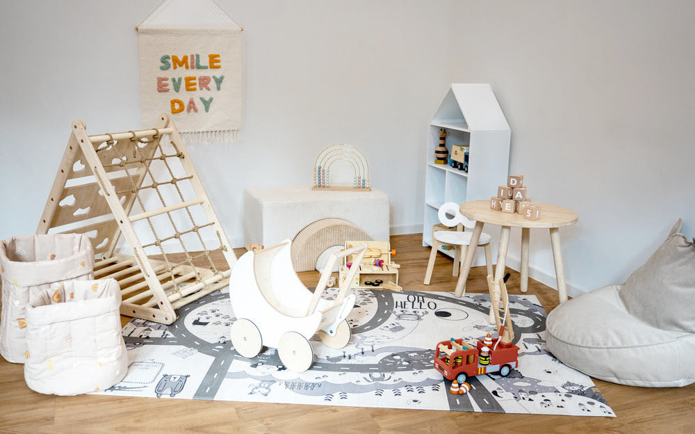 Kinderecke weiß modern mit Kletterdreieck, Puppenwagen und weiteren Spielsachen aus Holz