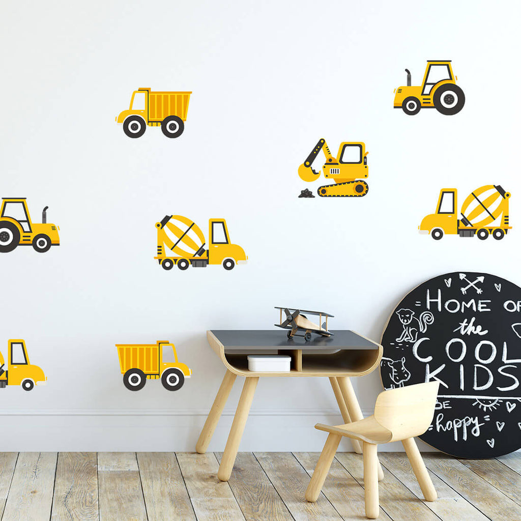 Kinderecke mit Tisch und Stuhl und gelben Baufahrzeugen an der Wand