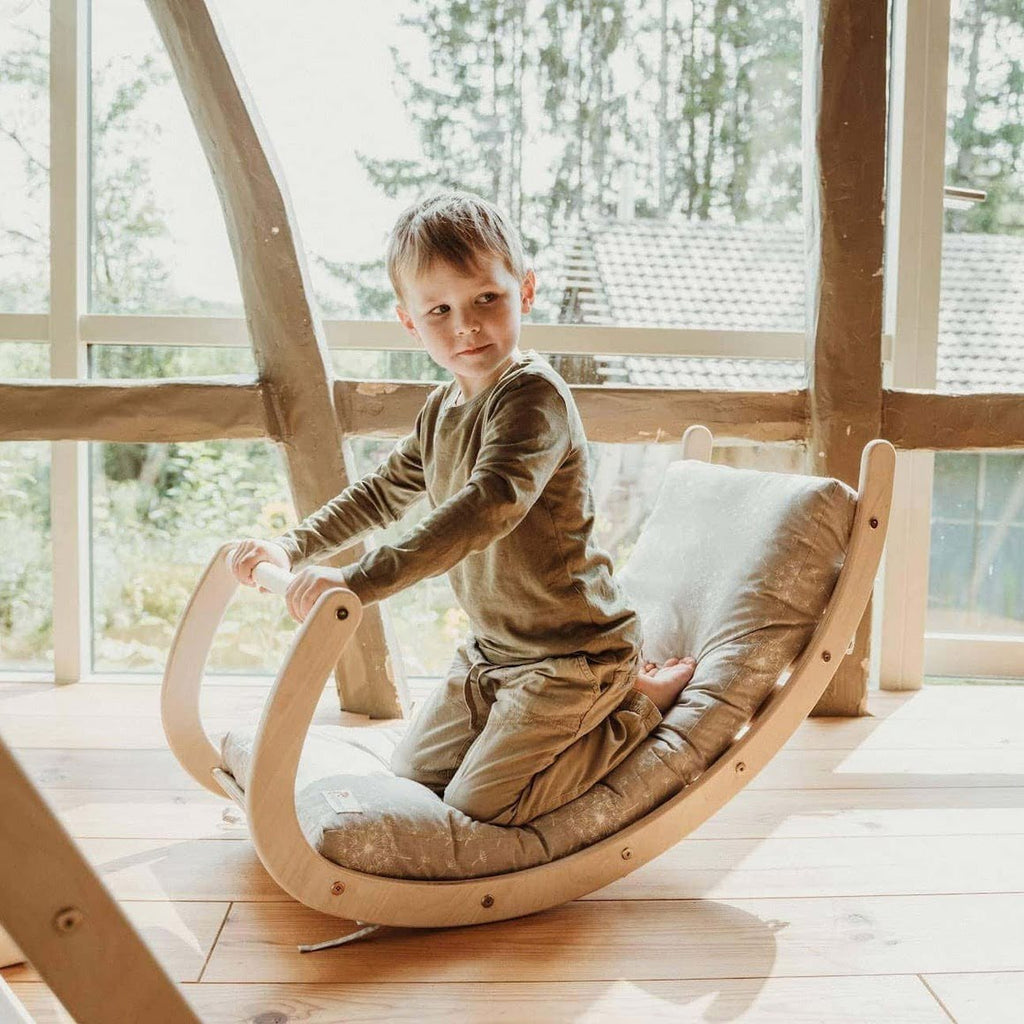 Asymmetrische Kletterwippe Holz mit Kind und Kissen