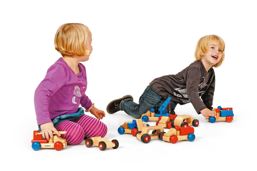 Kinder spielen mit Babyfahrzeuge aus Holz