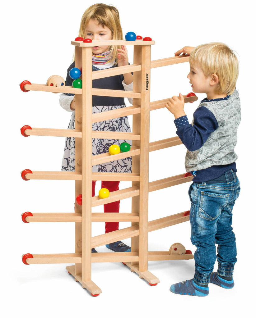 zwei Kinder spielen mit großer Kugelbahn aus Holz