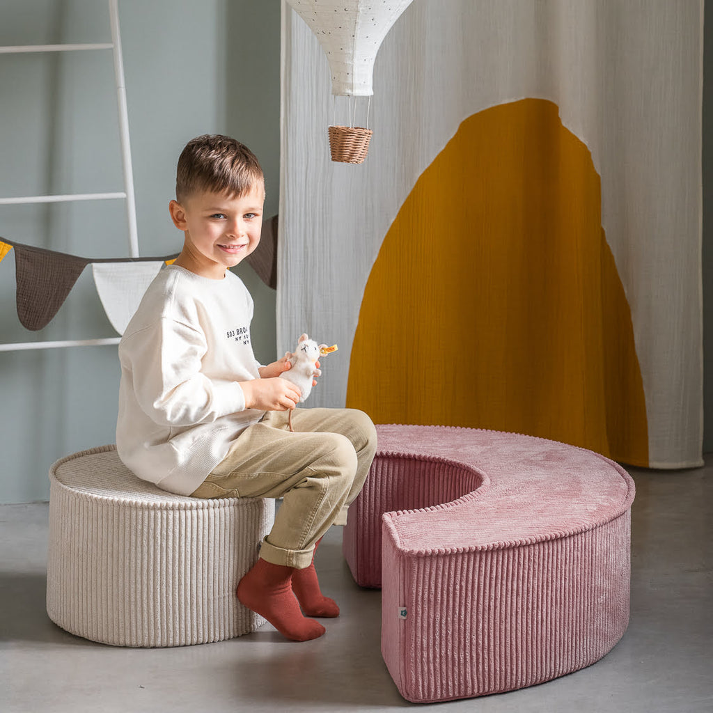 Kind sitzt auf Sitzpouf Schaumhocker Spielset breitcord rosa