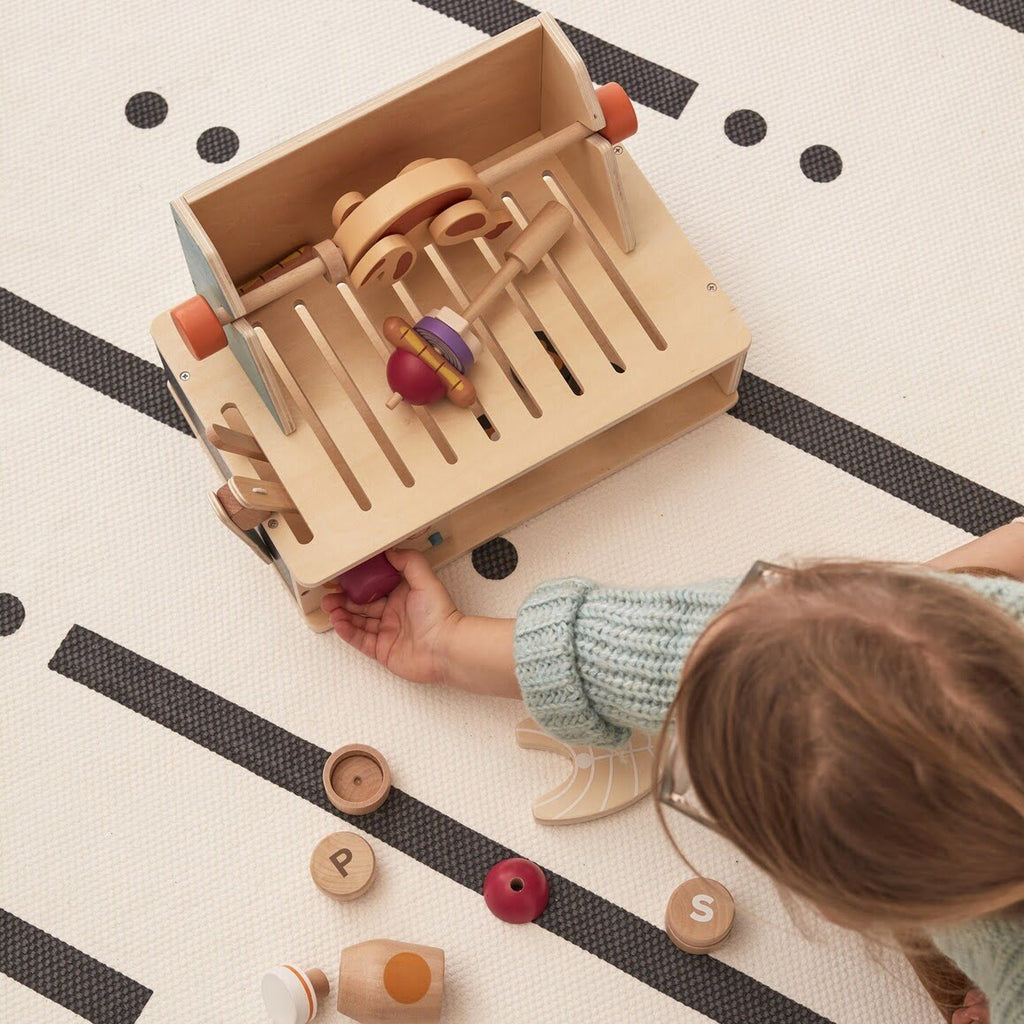 Tischgrill Spielzeug Holz auf Spielmatte mit Kind