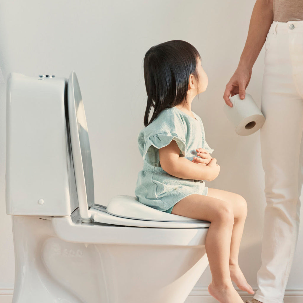 Kind auf Toilette mit Sitz
